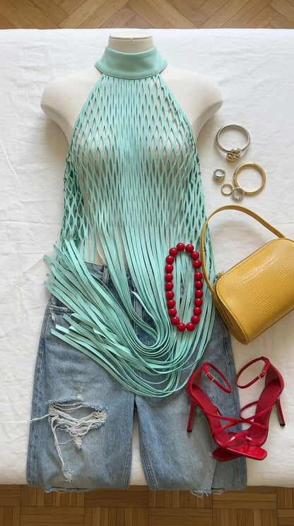 Flat lay of light blue halter fringe top with accessories and heels