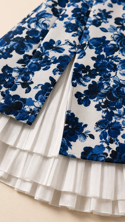 Close up detail of floral fabric and white pleated hem layers