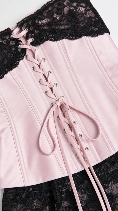 Close-up of pink satin corset bodice with black lace trim and lacing