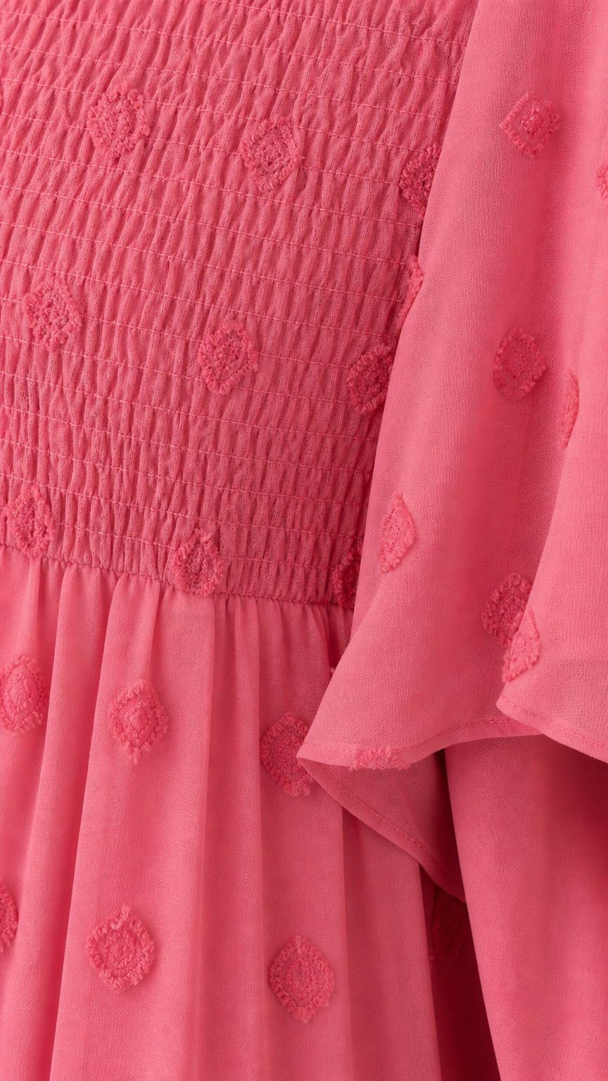 Close-up detail of smocked bodice and Swiss dot texture in Rose Pink