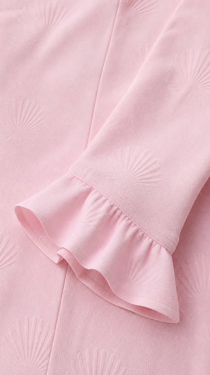 Close-up of blush pink textured jacquard fabric and ruffled sleeve cuff