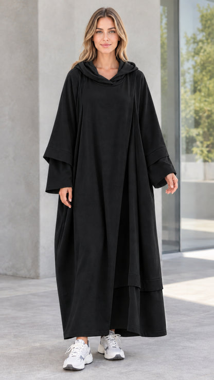 Front view of woman wearing black oversized hooded maxi dress