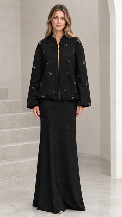 Full-length view of black beaded tweed jacket and maxi skirt two-piece set