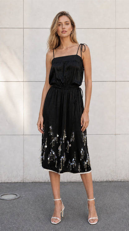Front view of model wearing black satin embellished midi slip dress