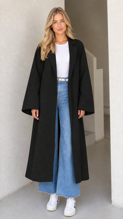 Model wearing Black open-front maxi duster coat with white top and denim jeans