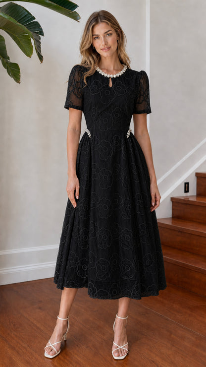 Model wearing black floral embroidered pearl neckline midi dress