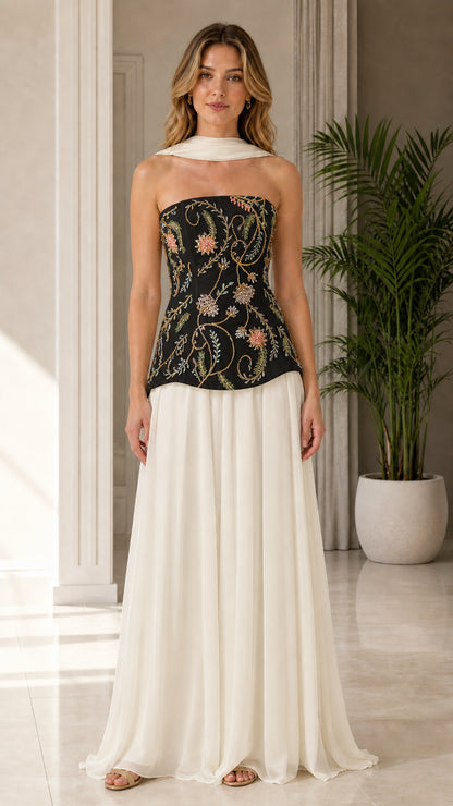 Model wearing black floral embroidered corset top with ivory flowing maxi evening skirt