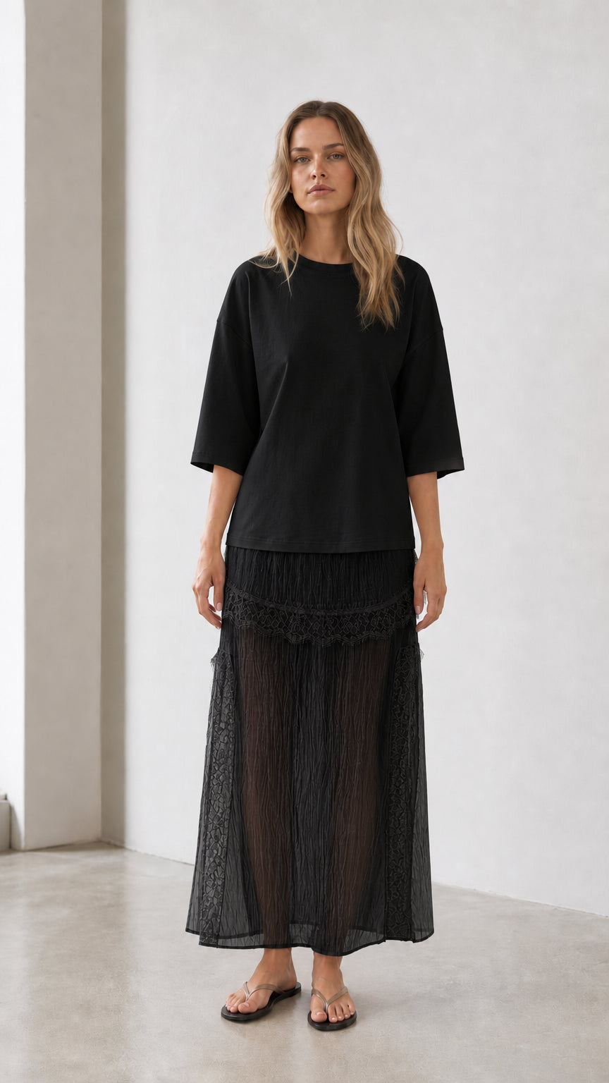 Front view of woman wearing black relaxed tee and matching skirt set
