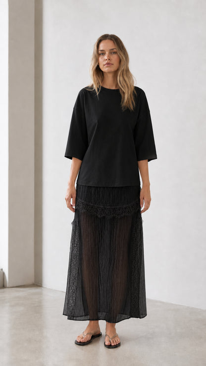 Front view of woman wearing black relaxed tee and matching skirt set