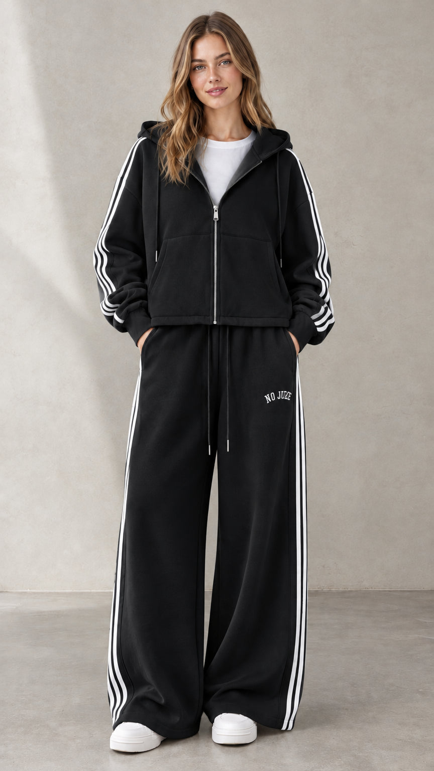 Woman wearing Black two-piece side-stripe zip-up hoodie and wide-leg sweatpants set
