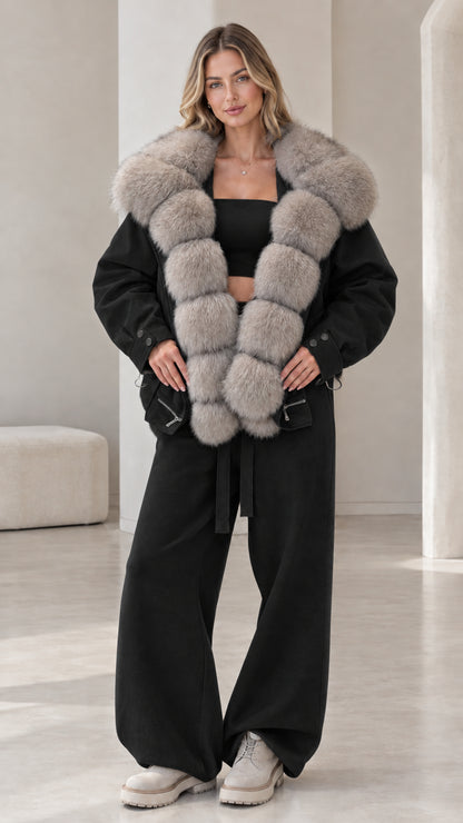 Model wearing black zip-up jacket with light grey faux fur collar and black wide-leg pants