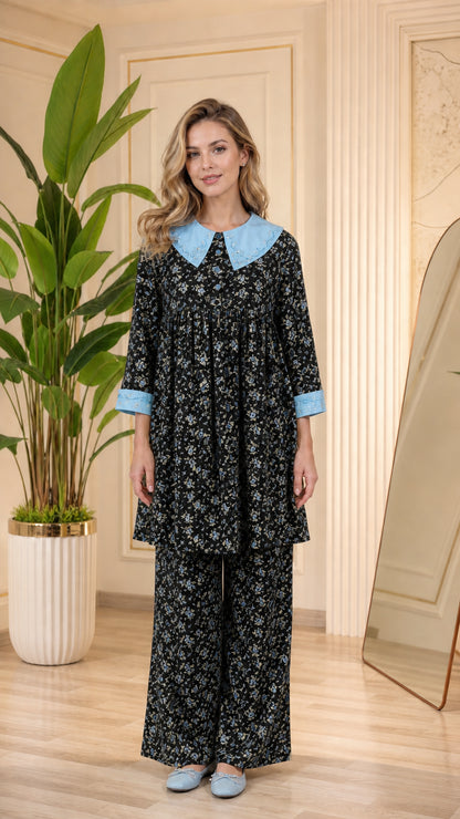 Model wearing black floral pajama set with light blue contrast collar and cuffs