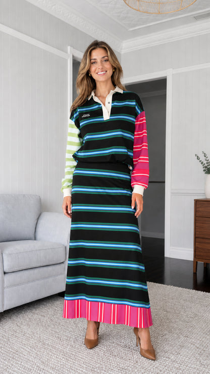 Woman wearing black colorblock striped polo sweatshirt and maxi skirt set