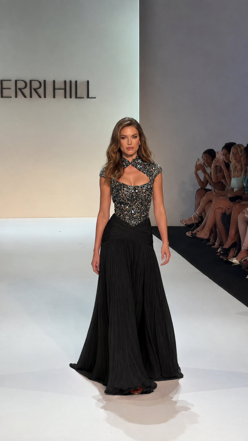 Model walking runway in Black embellished bodice pleated evening gown