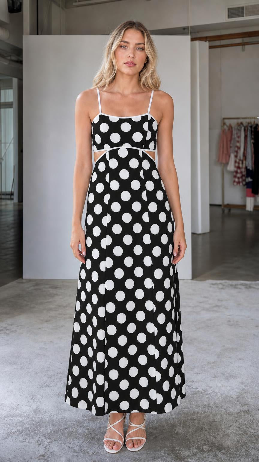 Front view of woman wearing black polka dot maxi dress