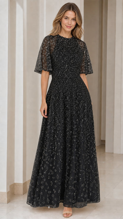 Woman wearing black sequin embroidered flutter sleeve maxi evening gown