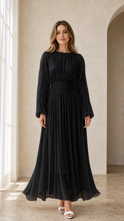 Model wearing black long sleeve pleated maxi evening dress