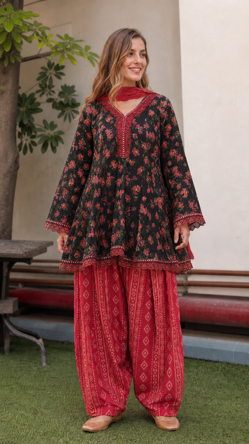 Model wearing black floral peplum tunic with red dhoti pants