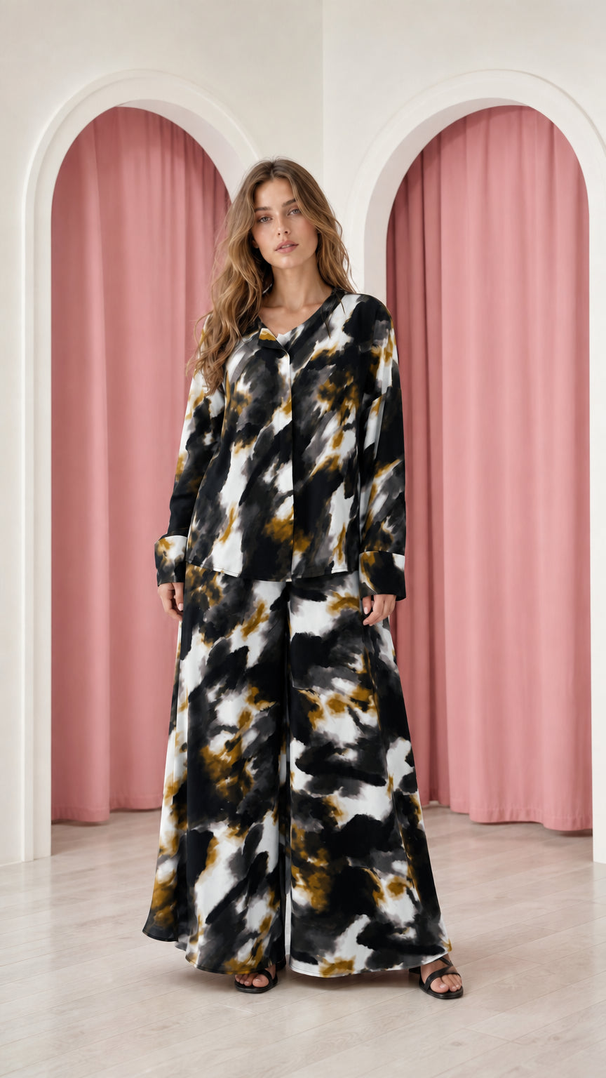 Model wearing black and white tie-dye satin top and wide-leg trousers set