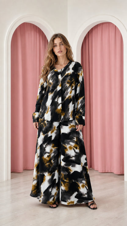 Model wearing black and white tie-dye satin top and wide-leg trousers set