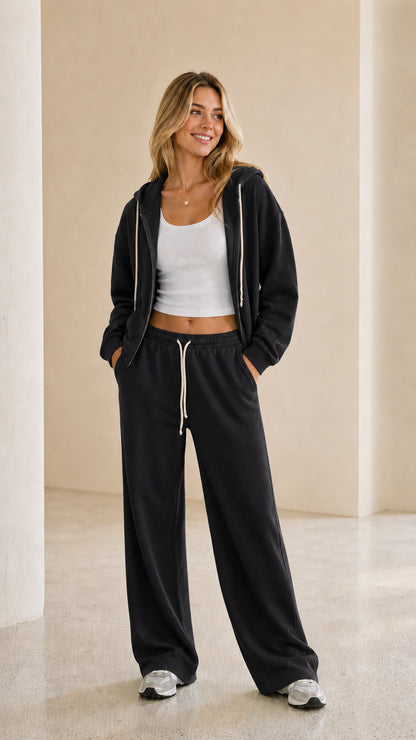 Model wearing black zip-up hoodie and wide leg pants tracksuit