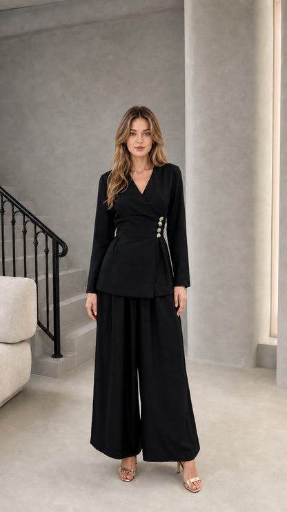 Model wearing black two-piece wrap top and wide leg trousers set