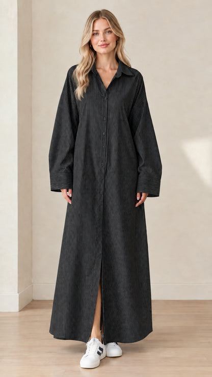 Front view of a model wearing a black and white striped long sleeve maxi shirt dress