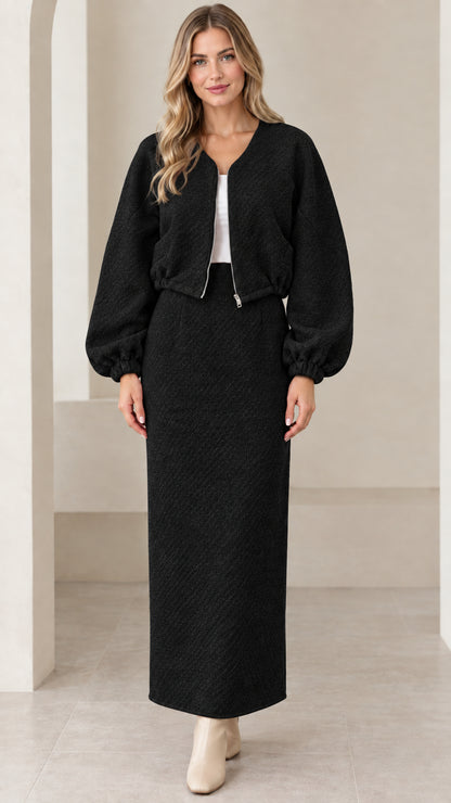 Full-length front view of black textured cropped jacket and maxi skirt set