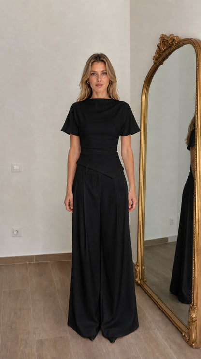 Front view of woman wearing black matching top and wide-leg pants