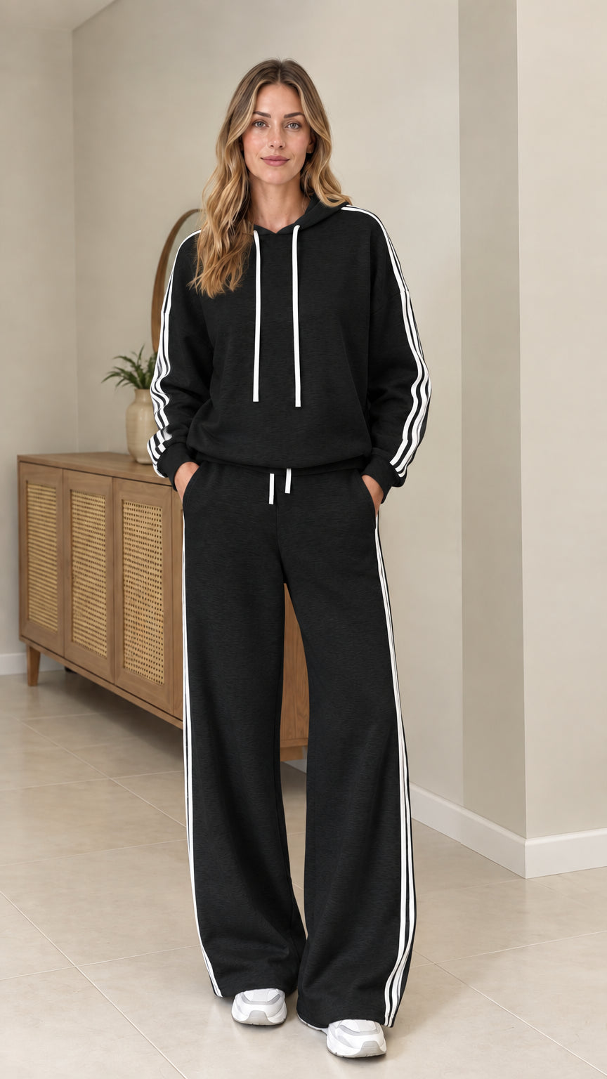 Model wearing Black two-piece tracksuit set with white side stripes