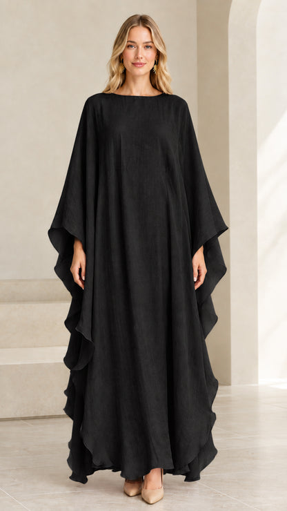 Model wearing black cascading ruffle kaftan maxi dress