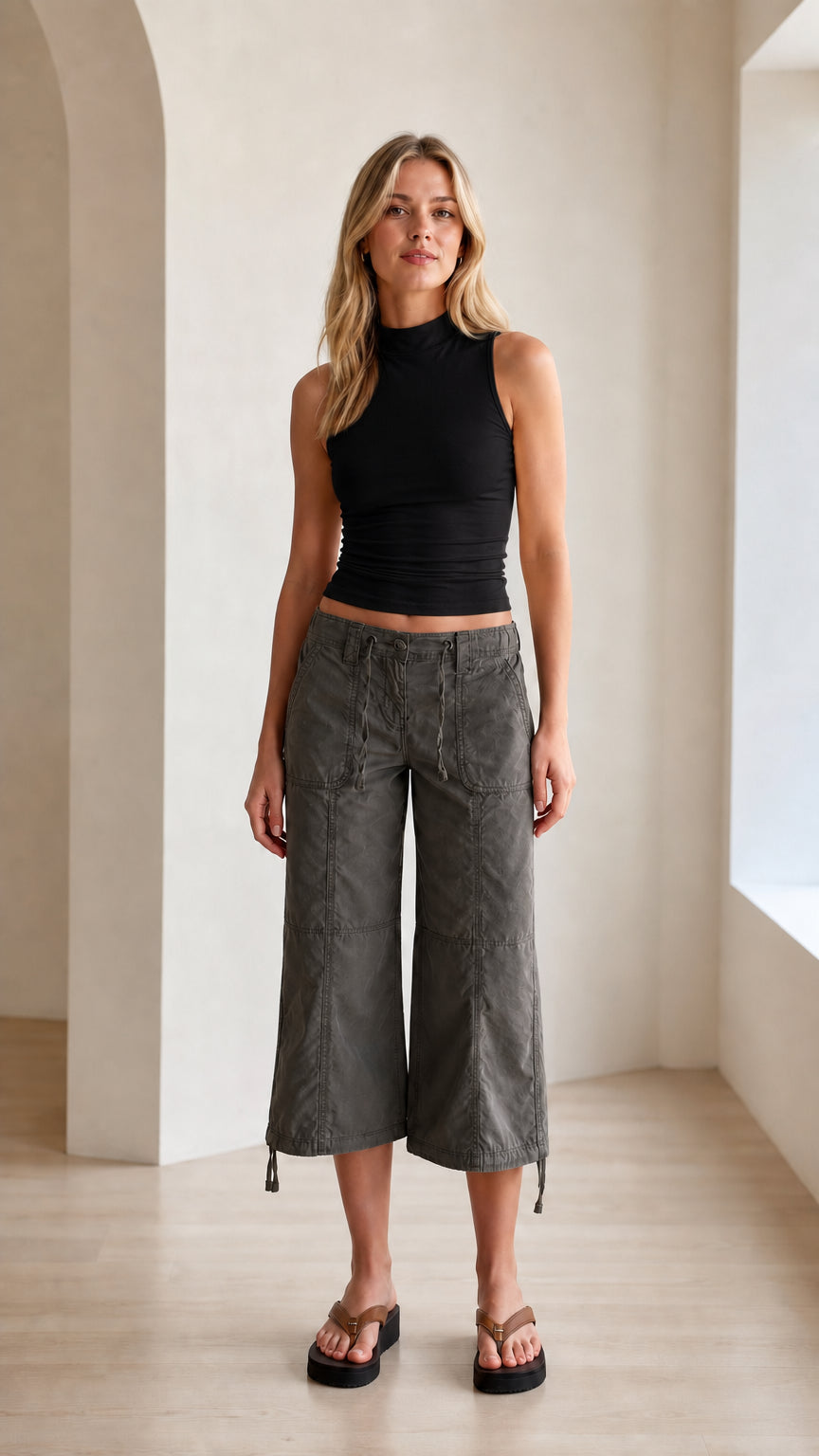 Model wearing black fitted mock neck sleeveless tank top