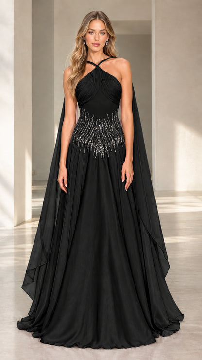 Front view of black halter neck beaded waist evening gown with cape drapes