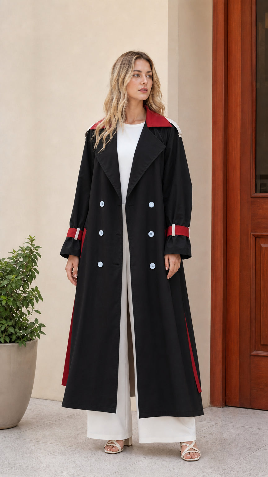 Front view of women's black long trench coat with red collar and cuff accents