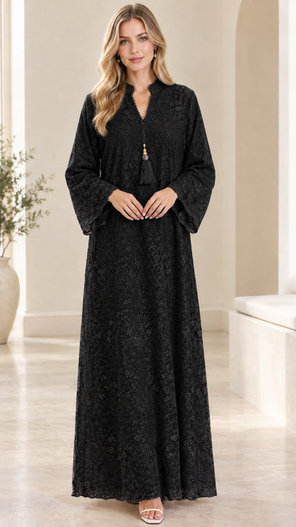 Front view of woman wearing black floral lace maxi dress with tassel neckline