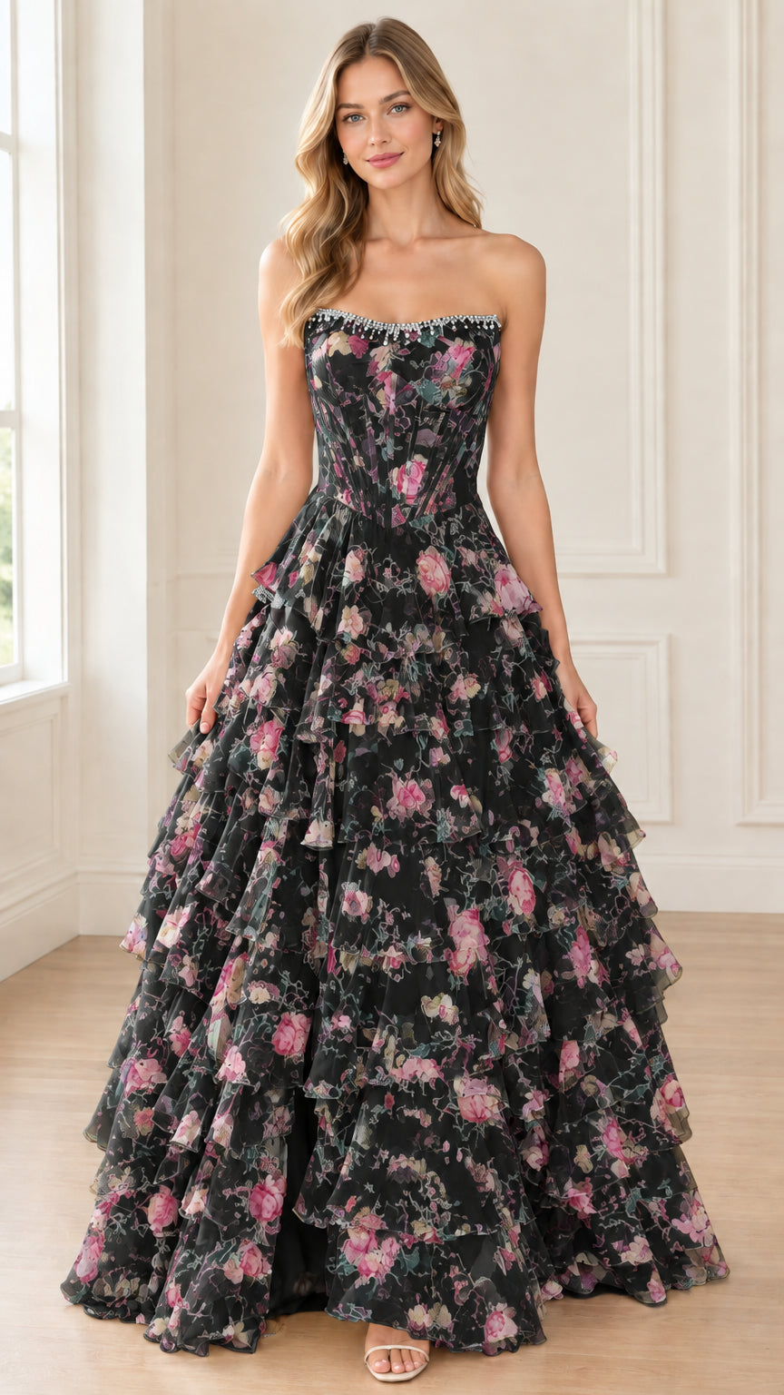 Front view of model wearing black floral strapless tiered corset ball gown