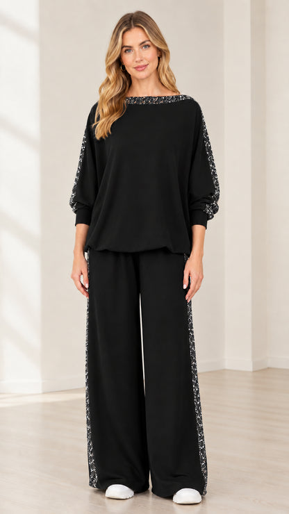 Woman wearing black 2-piece matching lounge set with sequin side stripe