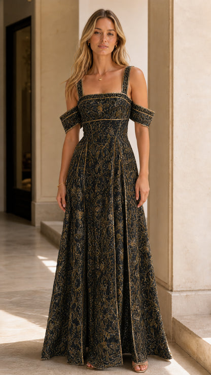 Model wearing black and gold embroidered cold-shoulder formal evening gown