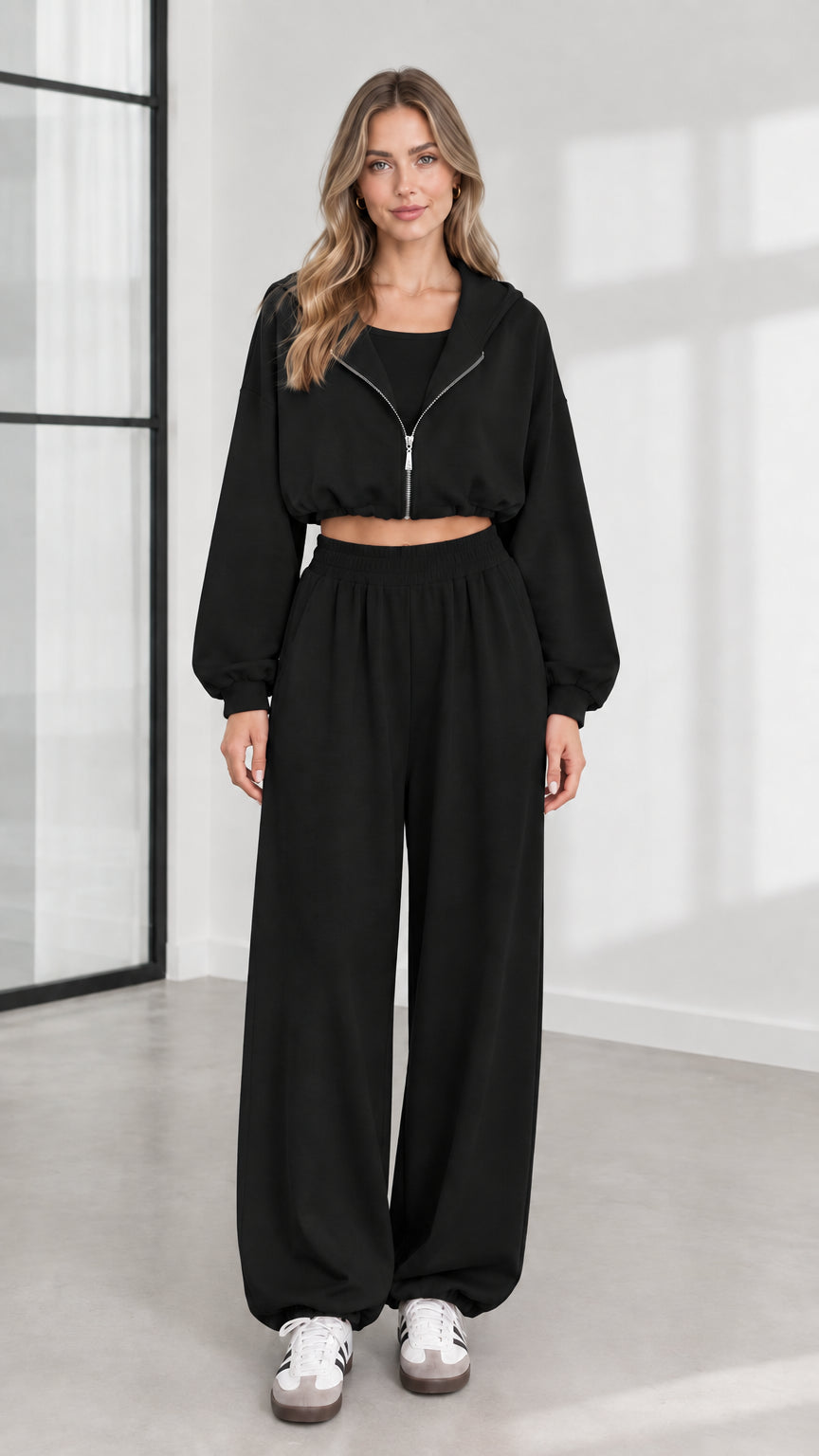 Front view of model wearing black 3-piece cropped zip hoodie and wide-leg sweatpants set