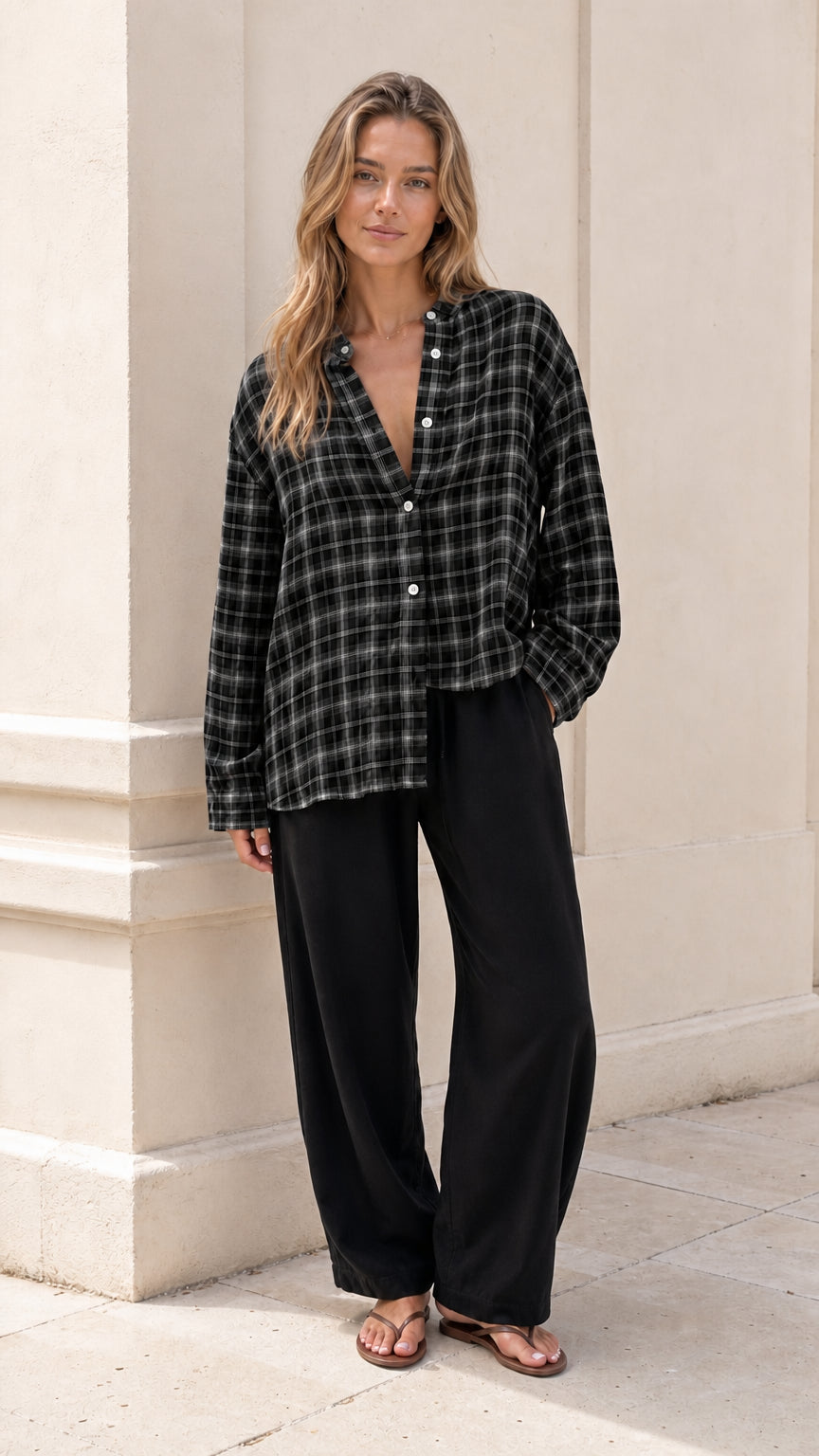 Model wearing black and white plaid band collar button-down blouse with wide-leg pants