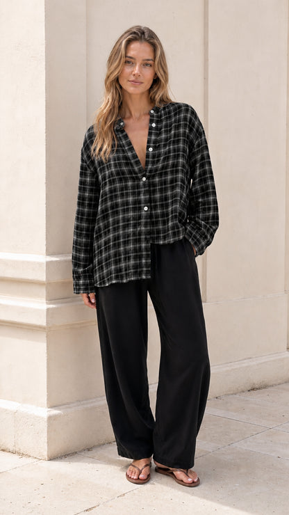 Model wearing black and white plaid band collar button-down blouse with wide-leg pants