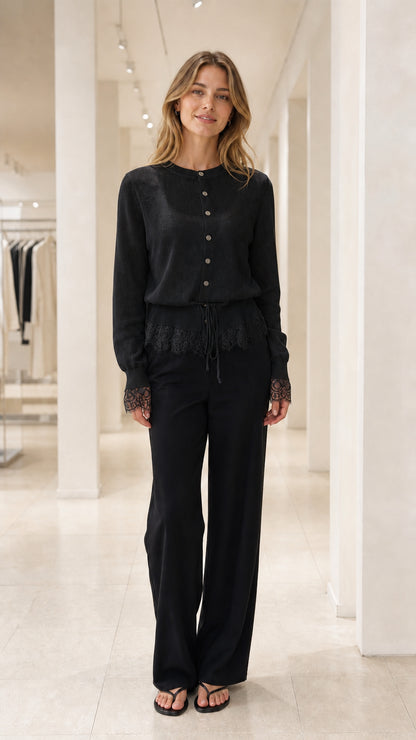 Front view of Black lace-trimmed knit cardigan and black trousers