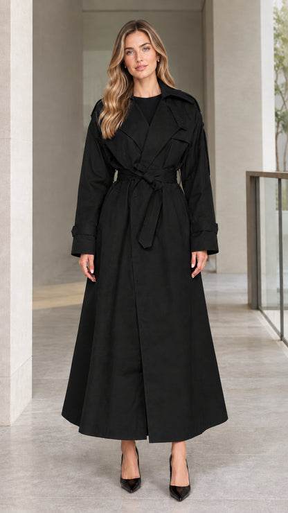 Front view of model wearing Black full-length belted maxi trench coat