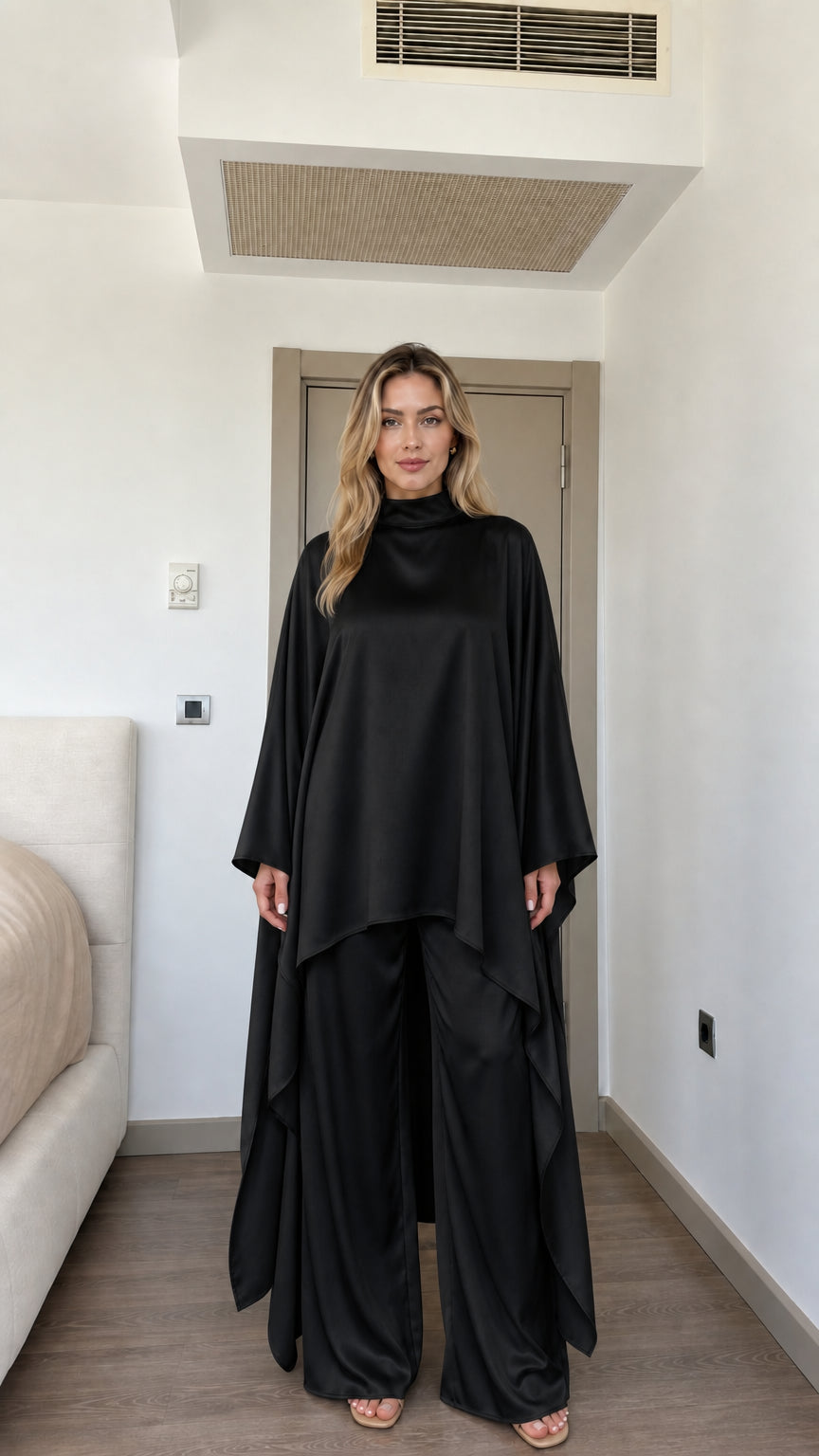 Front view of woman wearing Black satin high neck cape tunic and wide-leg pants set