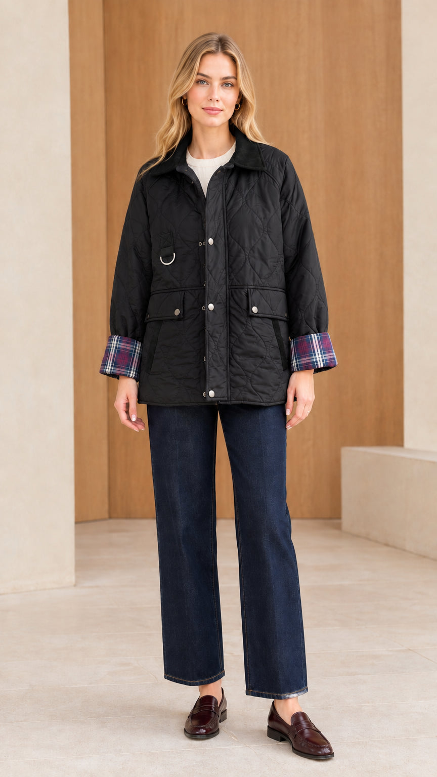 Front view of woman wearing black quilted barn jacket with corduroy collar