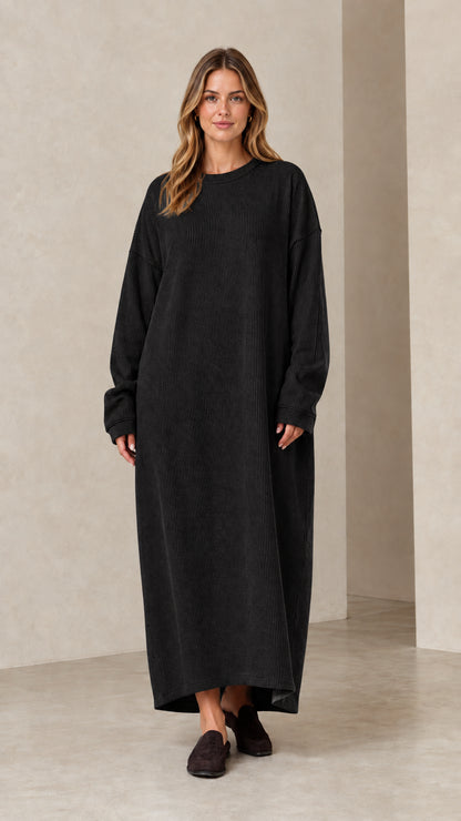 Woman wearing long sleeve black ribbed knit oversized maxi dress