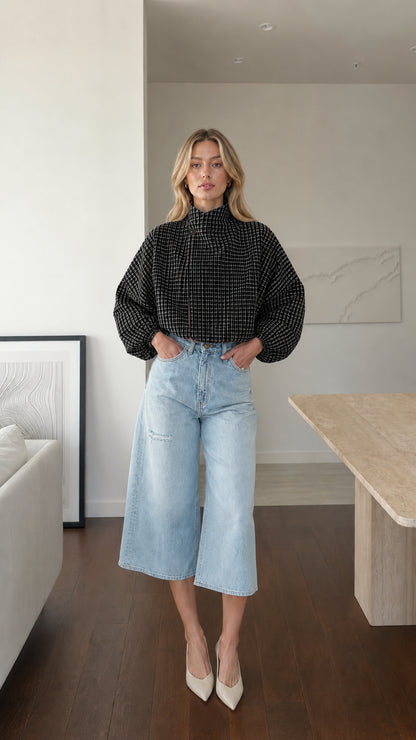Model wearing black plaid high-neck blouse