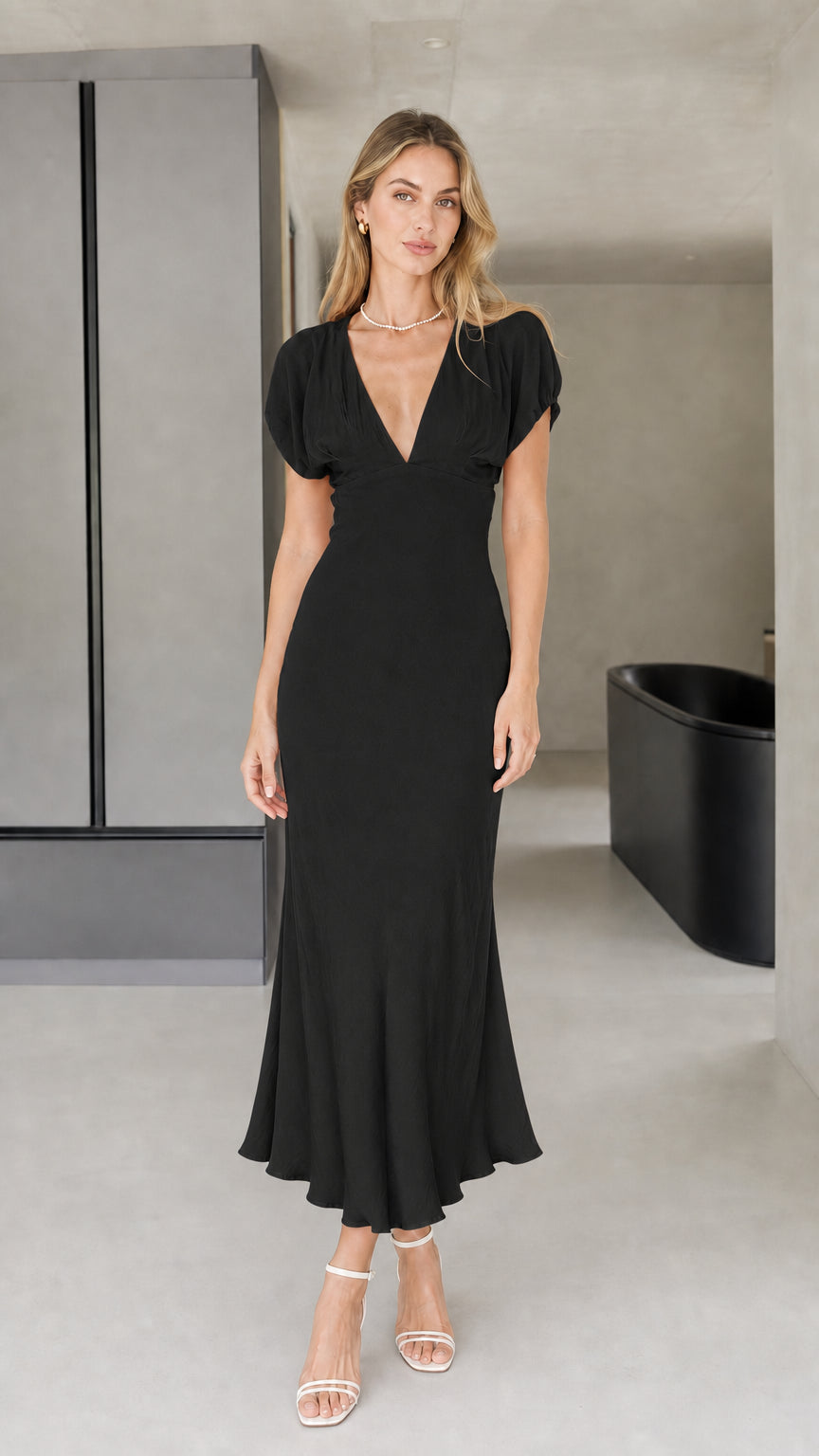 Front view of model wearing black midi dress