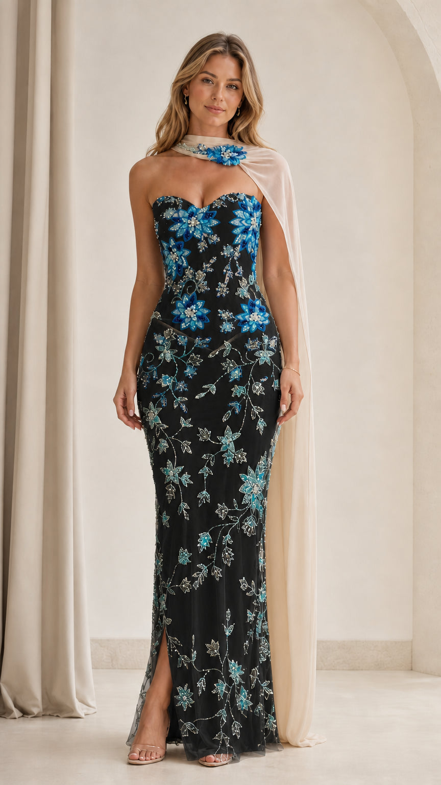 Model wearing black floral sequin strapless gown with champagne cape accent