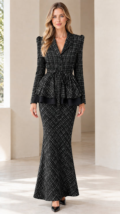 Front view of woman wearing black tweed peplum blazer and matching maxi skirt set